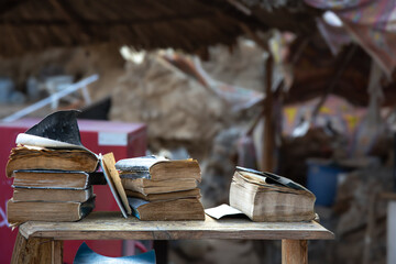 Old books lie on a heap on the counter of a flea market.