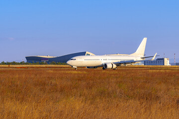 Fototapeta na wymiar Big passenger airplane drives along the runway in airport