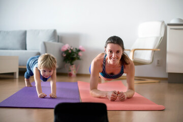 Mother and children, exersizing at home during coronavirus, people making gymnastic at home