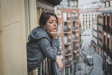 Young beautiful woman looking sad and depressed on a balcony in a depression concept.