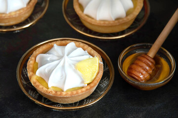 lemon tartlet with cream on a dark background.