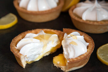 lemon tartlet cut in half with honey on a dark background