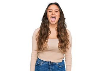 Obraz premium Young hispanic girl wearing casual clothes sticking tongue out happy with funny expression. emotion concept.