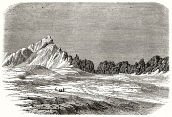 Milam glacier, India, on top of a mountain range and small people compared to huge flat ground. Ancient grey tone etching style art by De Bar, Le Tour du Monde, 1862 - 422278811