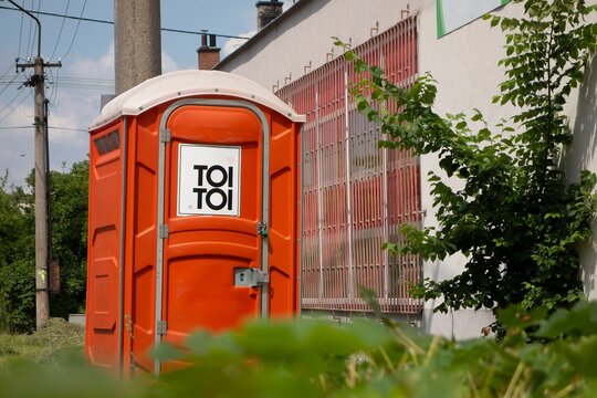 Orange ToiToi mobile toilet near the construction site
