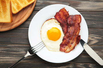 Eggs and bacon for breakfast on brown background. English breakfast