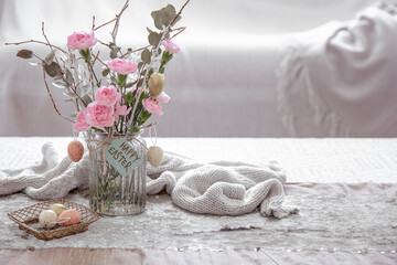 Festive composition Happy Easter with flowers in a glass vase and decor details on the table copy space.