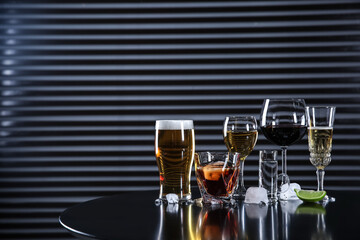 Many different alcoholic drinks on table against dark background. Space for text