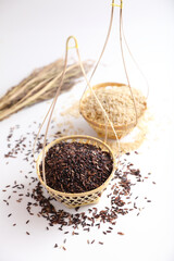 Organic raw brown rice and riceberry rice on wood basket in close up