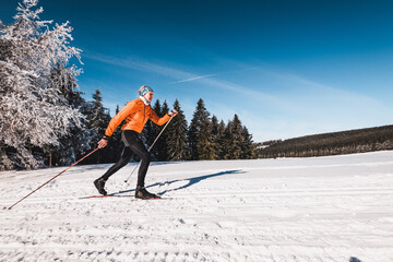 Langläufer in wunderschöner sonniger Winterlandschaft beim Skifahren klassische Technik