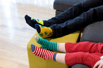 Down syndrome awareness concept. Man with boy wearing different socks. Different socks as symbol of...