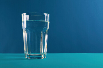 World Water Day. Glass of water fresh and pure water on blue background. The concept of clean, healthy water. Close up.