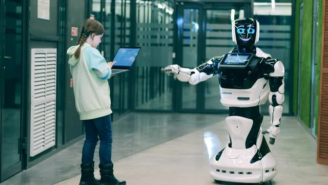 Kid operates a cybernetic robot with a laptop