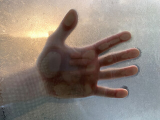 Hand melting the ice on a window