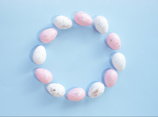 Creative copy space pattern made of pastel Easter eggs on sky blue background. Nature flat lay. Easter concept.