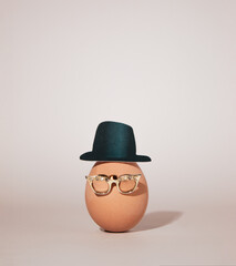Mister Easter egg with hat and gold eyeglasses. Minimal Easter concept.