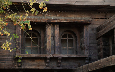 Old wooden house with wooden windows and shutters.