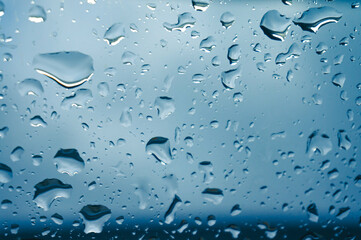 Rain drops on window glasses surface with sunset. drops on glass spray on window background for dark text view selective focus