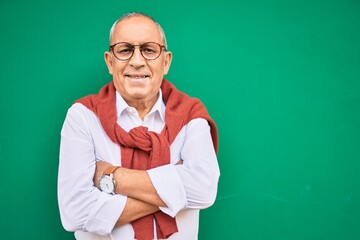 Senior man smiling happy wearing glasses walking at the city.