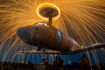 The plane is on fire. Fire show on an old plane. Fireworks on an abandoned plane.