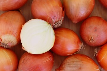 Onions slices on wooden cutting board.