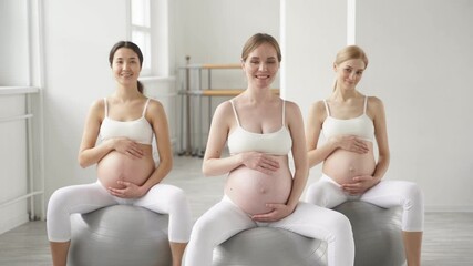 Cute diverse pregnant women with naked tummy sit on fitballs engaged in perinatal gymnastics, smiling, enjoying rest. - Powered by Adobe