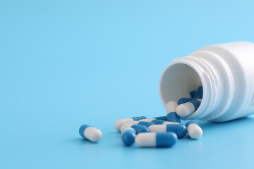pills capsules with bottle isolated on blue background