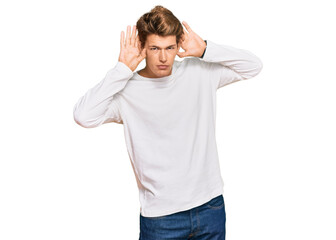 Handsome caucasian man wearing casual white sweater trying to hear both hands on ear gesture, curious for gossip. hearing problem, deaf