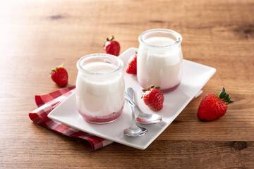 Panna cotta dessert with strawberry on wooden table