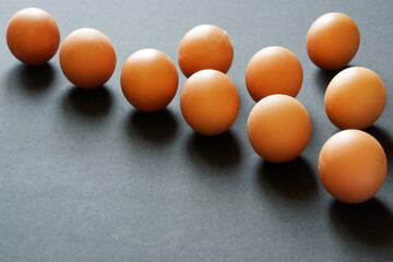 Ten brown chicken eggs lie on a gray surface. Preparing for Easter. Free space for an inscription