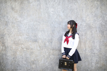 Portrait of Asian schoolgirl with grey background