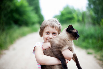 Girl on   street with   cat in   arms.