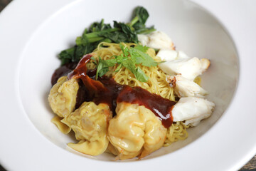 Shrimp dumpling noodles and crab meat on wood background