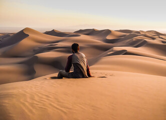 lonely young man contemplates the imnensity of the desert