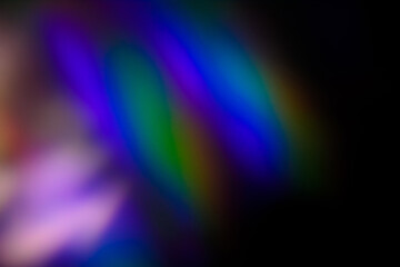 Blur colorful warm rainbow light leaks on black background with dust texture. Defocused abstract damaged scratched retro film analog effect for using over photos as overlay or screen filter