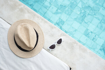 white sunglasses and hat near swimming pool in luxury hotel. Summer travel, vacation, holiday and...