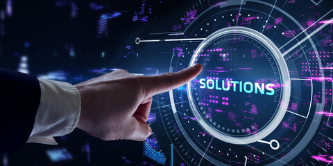 Business, Technology, Internet and network concept. Young businessman working on a virtual screen of the future and sees the inscription: Solutions