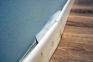 Damaged skirting board detached from the wall after the apartment was flooded.