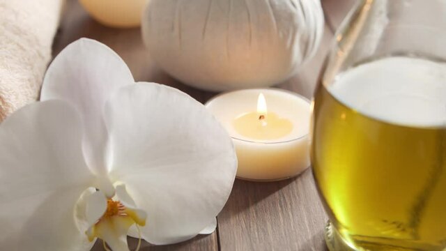 Spa background. Towel, candles, flowers, massaging stones and herbal balls. Massage, oriental therapy, wellbeing and meditation.