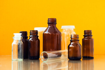 Dark brown phials on yellow background. Small empty bottles