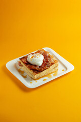 Delicious breakfast. Scrambled eggs with bacon on a yellow background