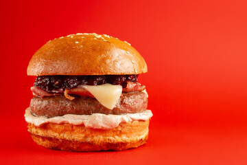 Delicious burger on a red background. Tasty fresh unhealthy burgers with cheese and two patties....