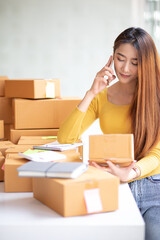 Portrait of Starting small businesses SME owners female entrepreneurs working, box and check online orders to prepare to pack the boxes, sell to customers, sme business ideas online.