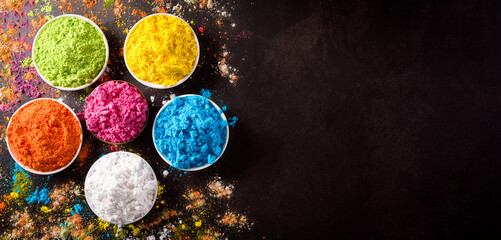 Happy holi festival decoration.Top view of colorful holi powder on dark background with copy space for text.