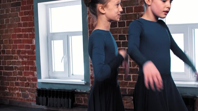 Ballet dancing - two ballerina girls dancing in long dark dresses on training