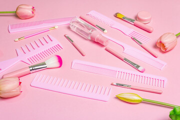 Makeup cosmetic set and hair combs on pink background
