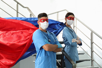 Fototapeta na wymiar Doctors dressed as superhero in hospital. Concept of medical workers fighting with COVID-19