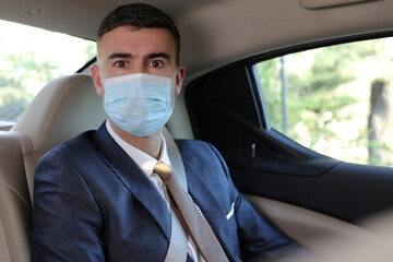 Businessman using taxi with protective mask 