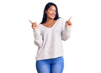 Hispanic woman with long hair wearing casual clothes smiling confident pointing with fingers to different directions. copy space for advertisement