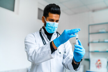 Portrait of an Indian doctor preparing to vaccinate a patient
